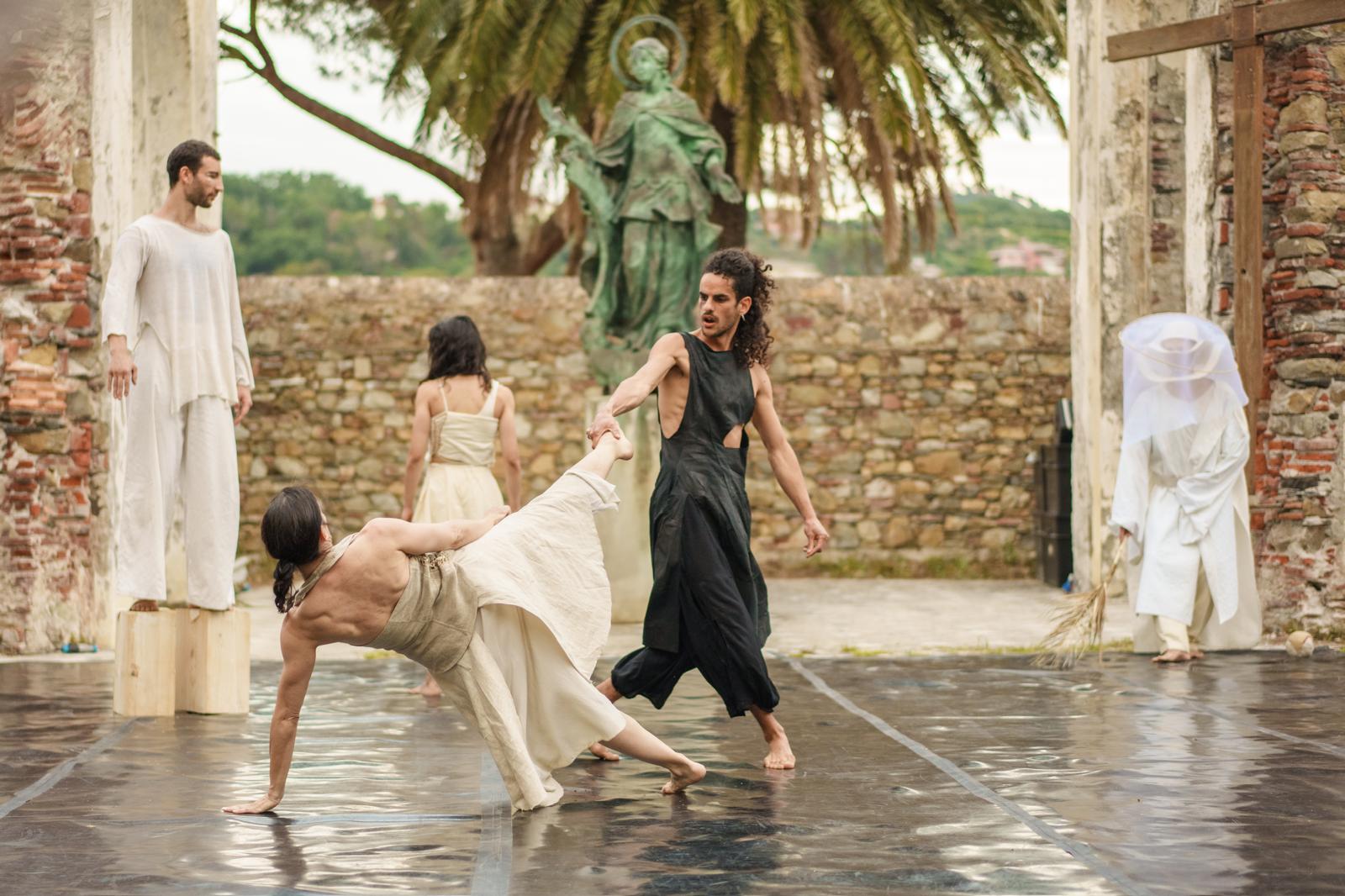 Dancers moving on an outdoor stage.