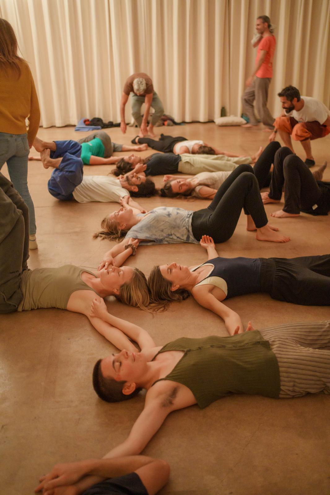 Participants lie on the floor during a guided body exercise.